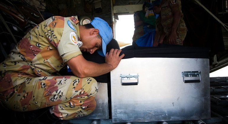 An Egyptian peacekeeper prays beside the coffins of two colleagues killed in action in South Darfur in May 2010. Three other peacekeepers were seriously wounded in an ambush carried out by a group of unidentified armed men.