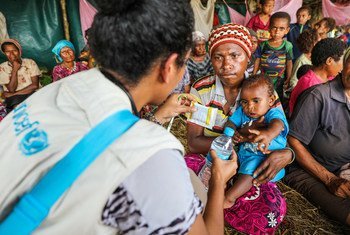 A UNICEF health official gives safe drinking water and oral retardation salts to a mother for her one-year-old child suffering from diarrhoea. They are living at temporary shelter along with at least 600 other persons after their homes were destroyed in the Papua New Guinea earthquakes.