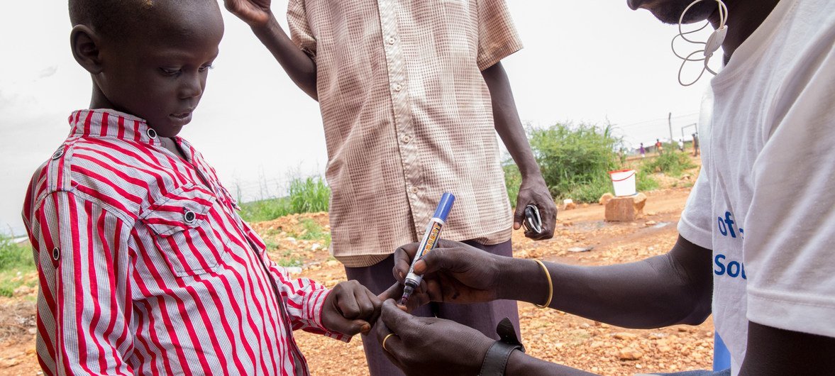 南苏丹一名健康工作者为一名儿童接种了霍乱疫苗后在他手上做了记号。