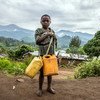 Un jeune garçon avec des récipients va chercher de l'eau sur le site de déplacés de Minova, dans le Sud-Kivu, en République démocratique du Congo.