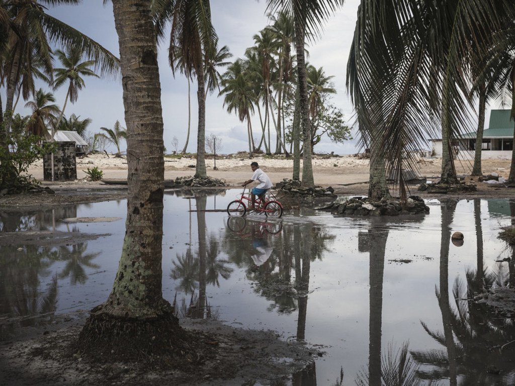 Criança anda de bicicleta, um Pequeno Estado Insular em Desenvolvimento que foi atingido por um furacão em 2019