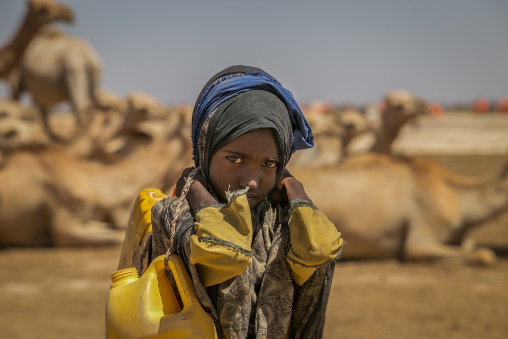 在埃塞俄比亚，一名九岁的女童正提着装满饮水的水桶，徒步返回四公里之外的家中。