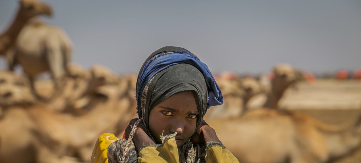 طفلة في التاسعة من العمر تحمل أوعية ملأتها بالماء من بئر يبعد أربعة كيلومترات عن منزلها.