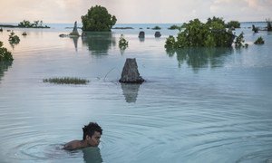 A 16-year-old child swims in the flooded area of Aberao village in Kiribati. The Pacific island is one of the countries worst affected by sea-level rise.
