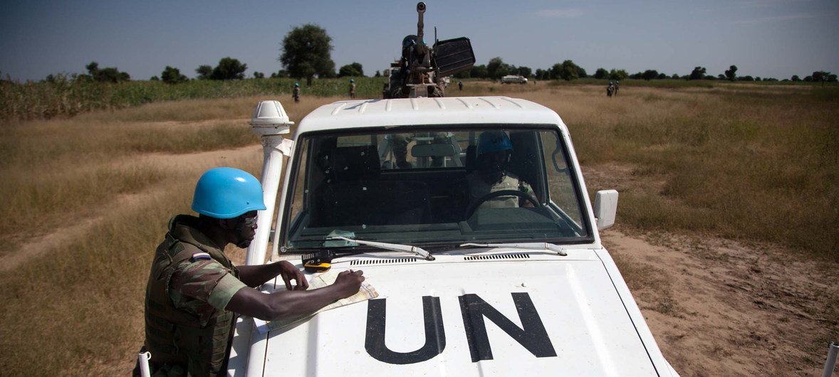 Un Casque bleu de la MINUAD originaire du Burkina Faso, basé à Forobaranga, dans l'ouest du Darfour (Soudan), vérifie une carte lors d'une patrouille vers le village de Tamar, en octobre 2013. 