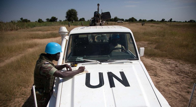 Un casco azul de la Misión Multidimensional Integrada de Estabilización de las Naciones Unidas en Mali, con sede en Forobaranga, en el oeste de Darfur, comprueba el mapa durante una patrulla en la aldea de Tamar, en octubre de 2013. 