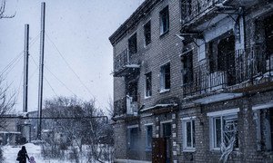  Une femme et un enfant marchant à l'extérieur d'un immeuble résidentiel détruit par des bombardements dans la ville de Marinka, Oblast de Donetsk, dans l'est de l'Ukraine. La crise dans la région a déplacé plus de 1,4 million de personnes de leurs foyers