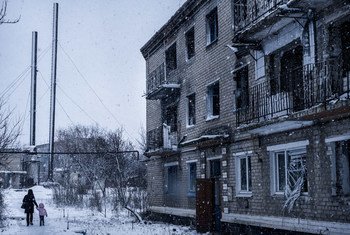  Une femme et un enfant marchant à l'extérieur d'un immeuble résidentiel détruit par des bombardements dans la ville de Marinka, Oblast de Donetsk, dans l'est de l'Ukraine. La crise dans la région a déplacé plus de 1,4 million de personnes de leurs foyers