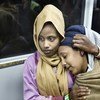 لاجئة من إريتريا تحتضن صديقتها في حافلة نقل في المطار. اللاجئتان من بين 162 لاجئا كانوا معرضين للخطر، حيث تم إجلاؤهم مباشرة من ليبيا إلى إيطاليا في أواخر ديسمبر 2017.