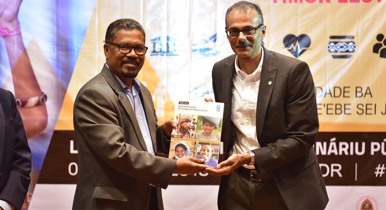 UN Resident Coordinator Mr. Roy Trivedy (right) hands over Timor-Leste's 2018 Human Development Report to the country's Minister for the Council of Ministers, Adriano do Nascimento (left).