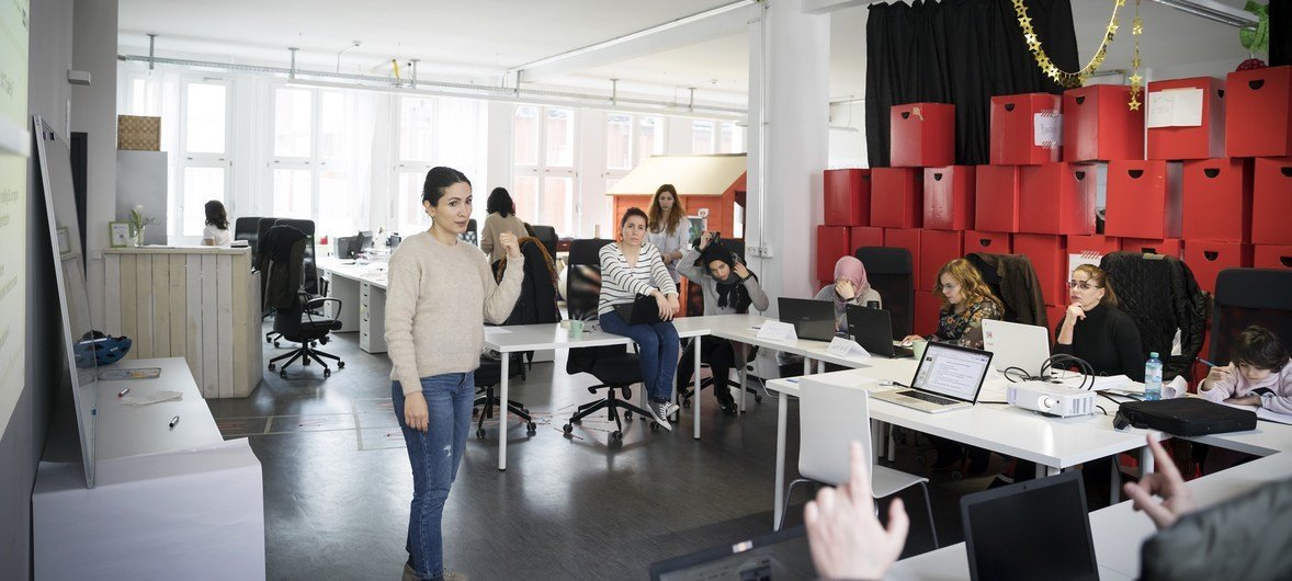 Nastaran Fekri (à gauche) et Rita Butmann (chemise à rayures) enseignent un cours de codage à l'école ReDI de Berlin. Ce cours de 3 mois permet aux réfugiés d’acquérir des compétences de base pour construire leur propre commerce en ligne.