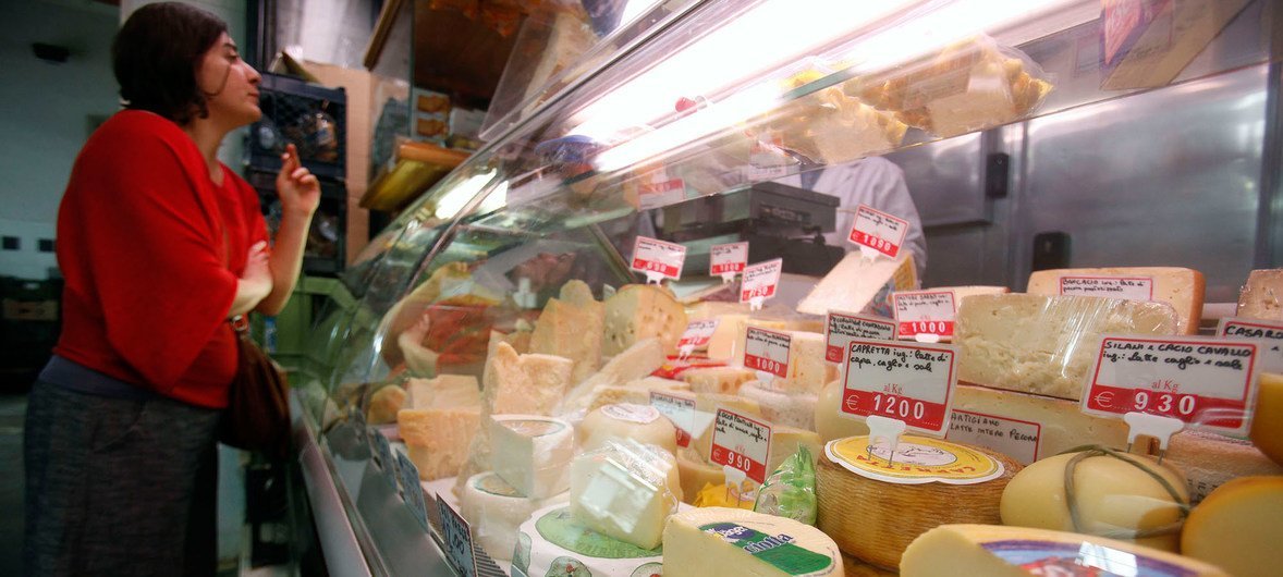 A customer buys cheese at a food stall at the Esquilino market in Rome. In nine cases analysed in a recent FAO study, origin-linked registration substantially increased the price of the final product. 