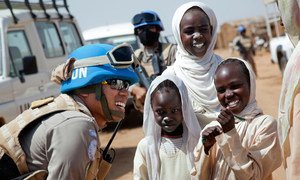 La teniente primera Sigit Jatmiko, miembro de la unidad de policía constituida de la Operación Híbrida de la Unión Africana y las Naciones Unidas en Darfur, habla con varios niños en el campamento de desplazados Abu Shouk durante una patrulla.