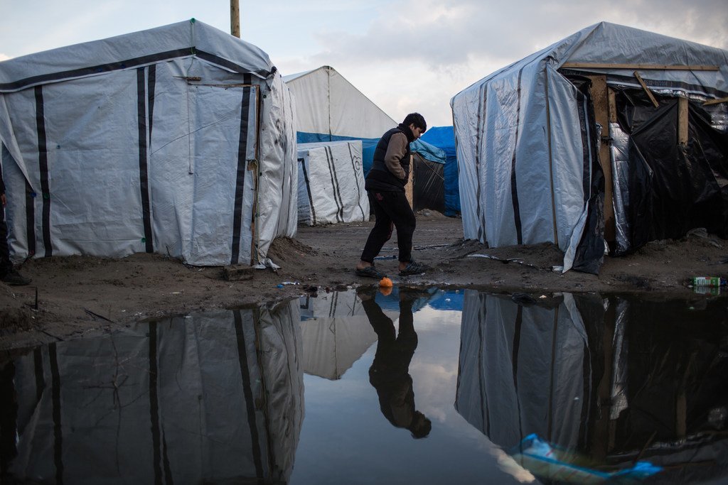 صبي يمشي في مخيم للمهاجرين في كاليه، شمال فرنسا. وفقًا للتقديرات، يحتمي حوالي 900 مهاجر وطالب لجوء في المنطقة، والعديد منهم بدون مراحيض أو مرافق الاغتسال.