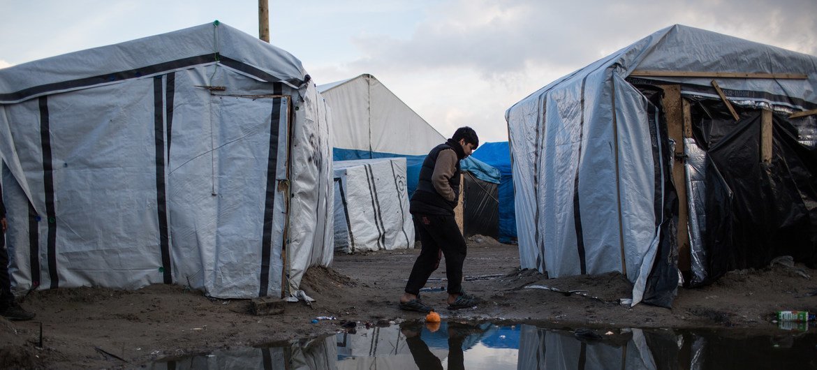 A boy walks through a migrant camp in Calais, northern France. Many asylum seekers attempt the sea crossing to England from the French coast.