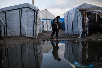 Menino caminha por um acampamento de migrantes em Calais, norte da França 