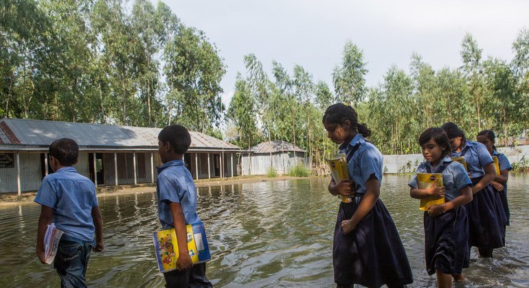 Varios estudiantes van al colegio tras las fuertes inundaciones en Bogra, Bangladesh, el 9 de septiembre de 2014. 