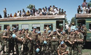 عناصر هولندية من قوة الأمم المتحدة الانتقالية في كمبوديا (UNTAC) ، تحرس قطارا يحمل اللاجئين العائدين إلى كمبوديا من المخيمات في تايلاند. أيار/مايو 1993.