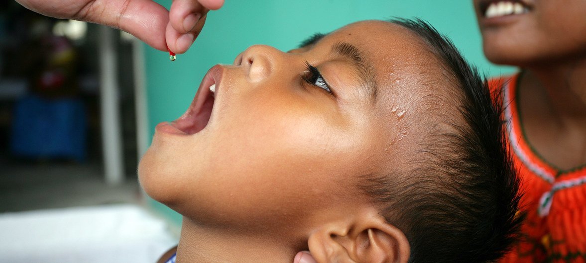 Трехлетний мальчик из Кирибати получает дозу витамина А в виде капель