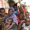 सोमालिया के बेलेट वेयन शहर में बाढ़ पीड़ित एक महिला अपने बच्चों के साथ एक राहत शिविर में.