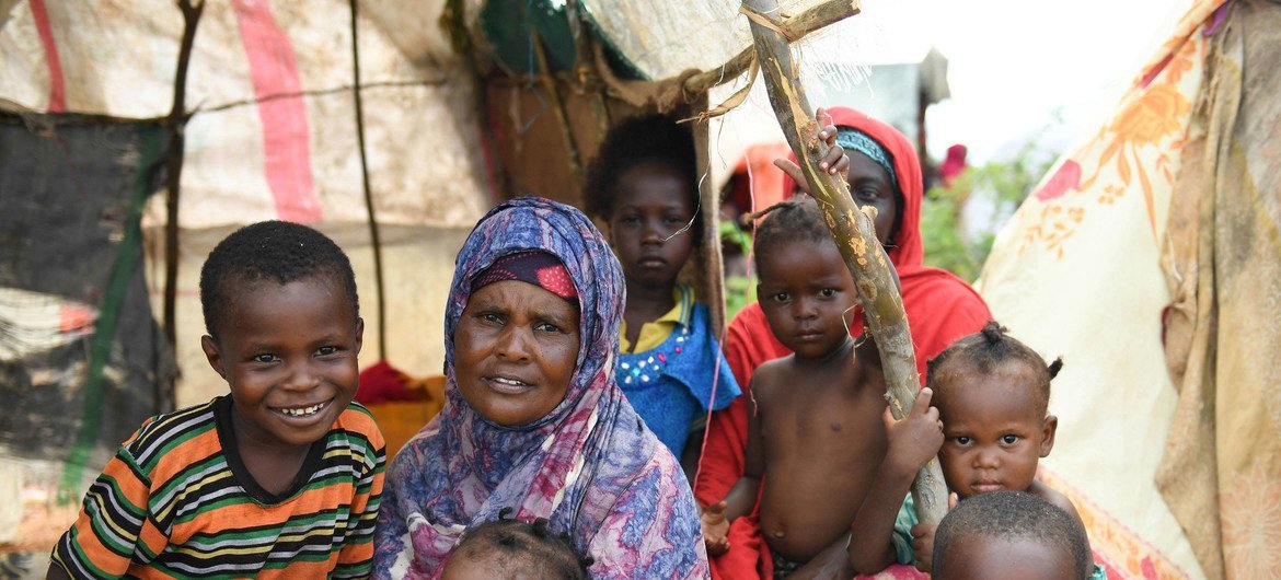 सोमालिया के बेलेट वेयन शहर में बाढ़ पीड़ित एक महिला अपने बच्चों के साथ एक राहत शिविर में.
