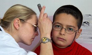 Un médecin français de la FINUL effectue un bilan de santé sur un élève de l'école publique de Burj Qalaway, au Sud-Liban, en 2013. 