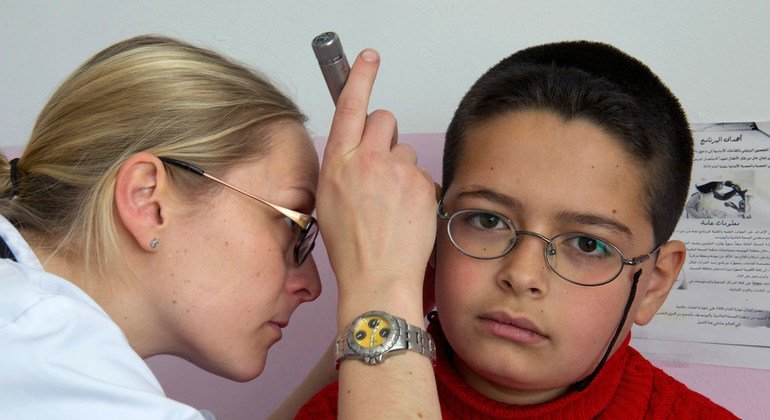 Un médecin français de la FINUL effectue un bilan de santé sur un élève de l'école publique de Burj Qalaway, au Sud-Liban, en 2013. 