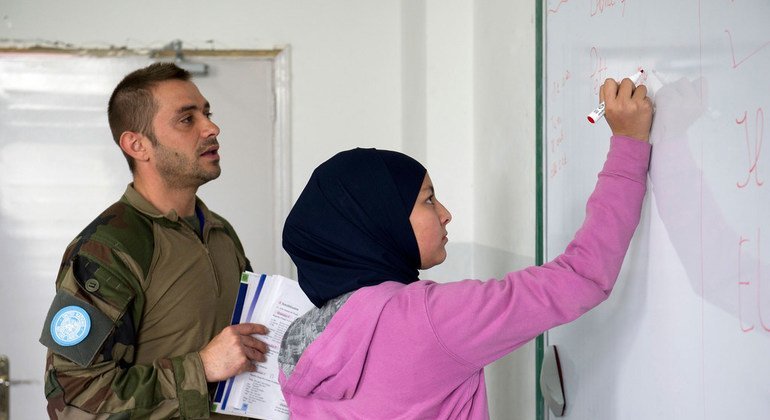Un soldat de la paix français de la FINUL instruit unz élève pendant des cours de français à l'école publique de Burj Qalaway, au Sud-Liban, en 2013. 