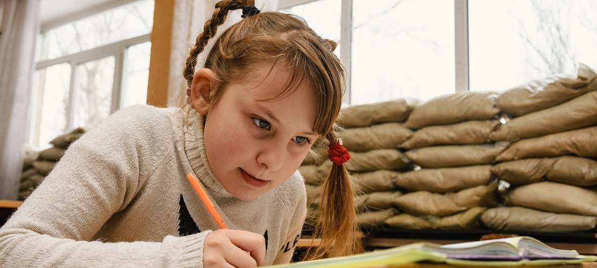 Из-за конфликта на востоке Украины дети вынуждены учиться в школах, окна которых заставлены мешками с песком - это защищает их от обстрелов