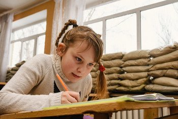 Из-за конфликта на востоке Украины дети вынуждены учиться в школах, окна которых заставлены мешками с песком - это защищает их от обстрелов