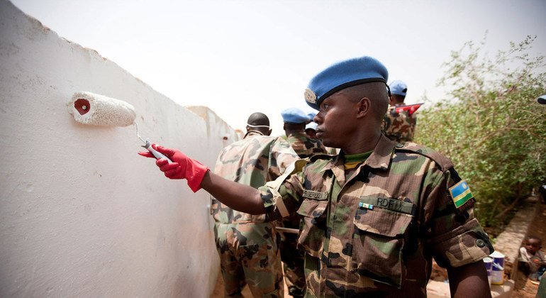 A UNAMID peacekeeper from Rwanda paints a wall at the Alfaki Abdallah Albigawi Basic Level School for girls in El Fasher, North Darfur, as part of the commemoration of the 2011 Nelson Mandela International Day.