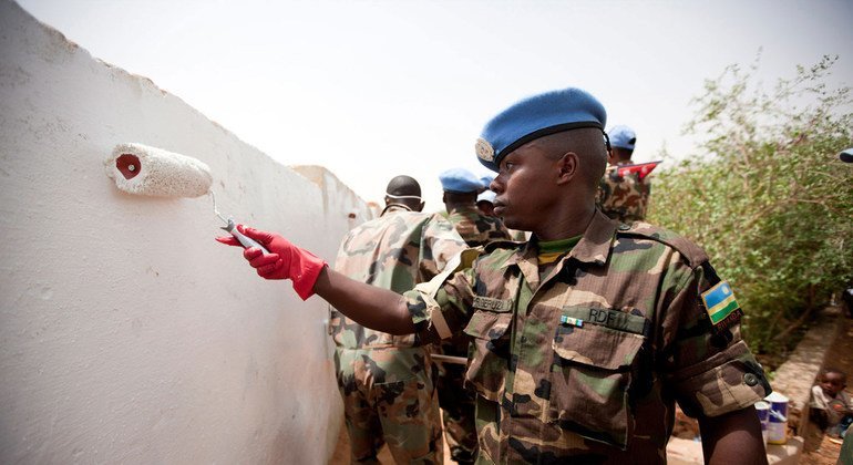 Personal de mantenimiento de la paz de UNAMID de Rwanda pinta un muro en la escuela de Alfaki Abdallah Albigawi en El Fasher, en el norte de Darfur, para conmemorar el Día Internacional de Nelson Mandela en el 2011.  