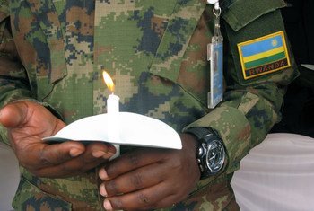 Soldado da paz segura vela em memória das vítimas do genocídio de 1994 no Ruanda. 