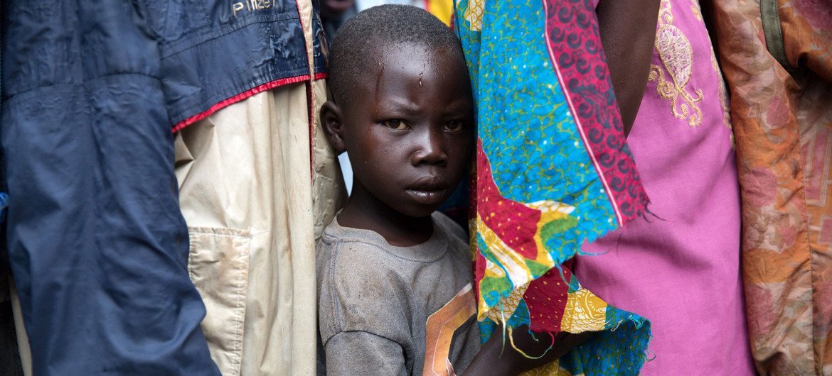 Un garçon attend avec d'autres réfugiés sud-soudanais d'être enregistré dans un centre de réception en Ouganda.