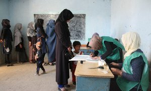 Afghan men and women register as voters at a centre in Bamyan ahead of elections in October 2018.
