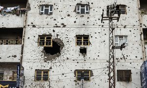 Здание в Сане, Йемен, сильно повреждено пулевыми отверстиями и большой дырой от взрыва.