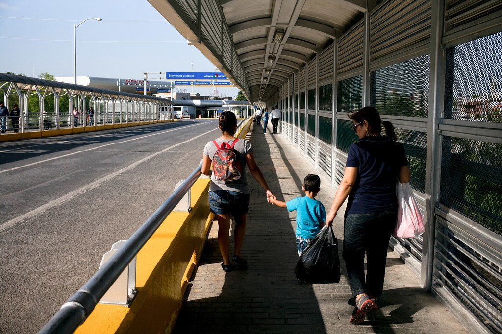 In this file photograph, migrants, including a child, cross the border over the Rio Grande, connecting Reynosa in Mexico with McAllen in Texas, the United States.