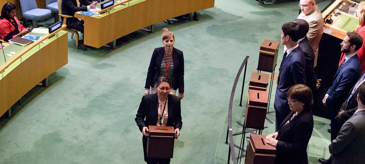 UN staff carry ballot boxes with votes cast during the election of five non-permanent members of the Security Council.