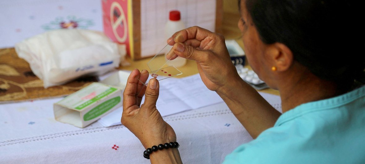 Trabalhadora de saúde prepara teste de malária.