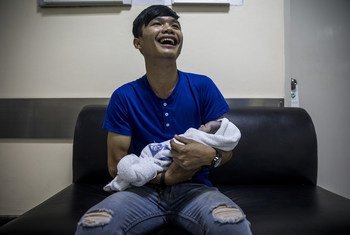 A man cries with laughter as he holds his newborn baby, born a few moments before at Lerdsin Hospital, Bangkok, Thailand.