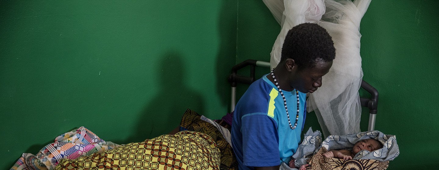 Un joven cuida a su hijo recién nacido en Guinea-Bissau.