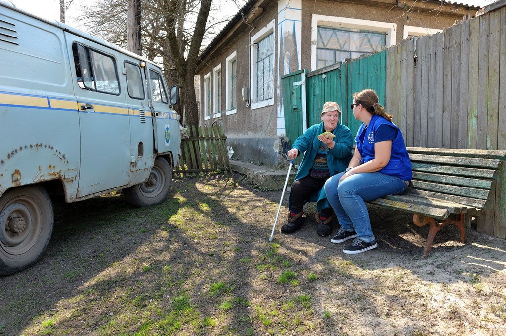 An elderly woman in village Krymskoe, heavily affected by the armed conflict, receives financial assistance from IOM.