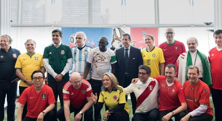 身穿球衣的各成员国代表在联合国总部大楼合影。