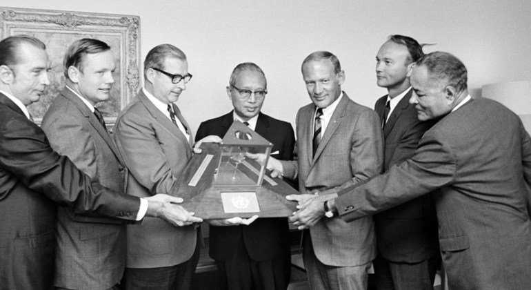 La bandera de las Naciones Unidas acompaña a los astronautas estadounidenses Neil Armstrong, Edwin Aldrin Jr. y Michael Collins en su viaje a la Luna sobre el Apollo 11. En la imagen, los tres astronautas visitan la sede de la Organización y entregan al S