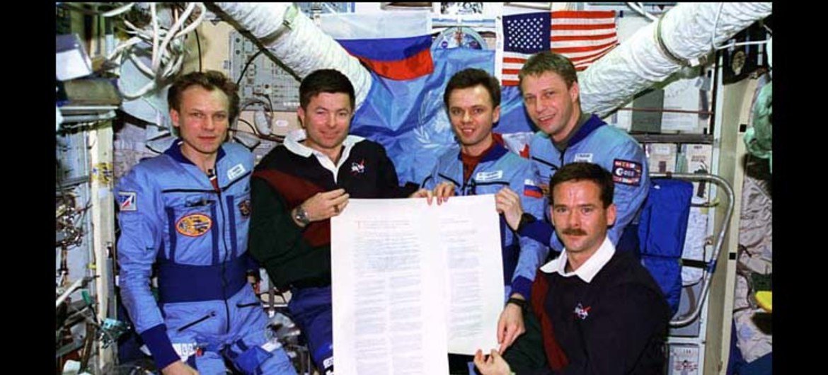 Российские и американские астронавты из экипажа программы «Мир-Шаттл» демонстрирует экземпляр Договора о космосе