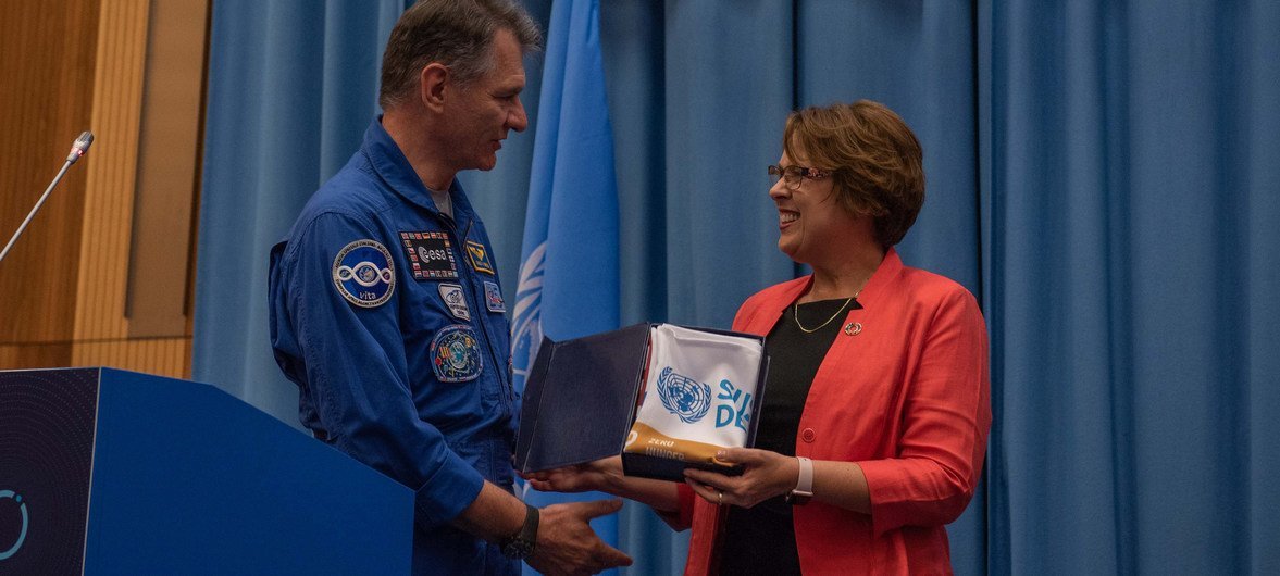 European Space Agency astronaut Paolo Nespoli presents the SDG flag he flew abroad the International Space Station to UNOOSA Director Simonetta Di Pippo.