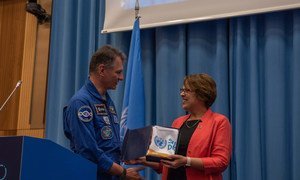 欧洲航天局宇航员保罗-内斯波利向联合国外层空间事务厅主任迪皮波赠送曾搭载国际空间站的可持续发展目标旗帜。