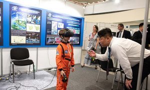 Un niño en traje de astronauta  ve la luna en realidad virtual, en la exhibición del Programa de Exploración Lunar Chino. 