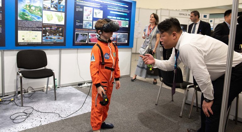 Un niño en traje de astronauta  ve la luna en realidad virtual, en la exhibición del Programa de Exploración Lunar Chino. 