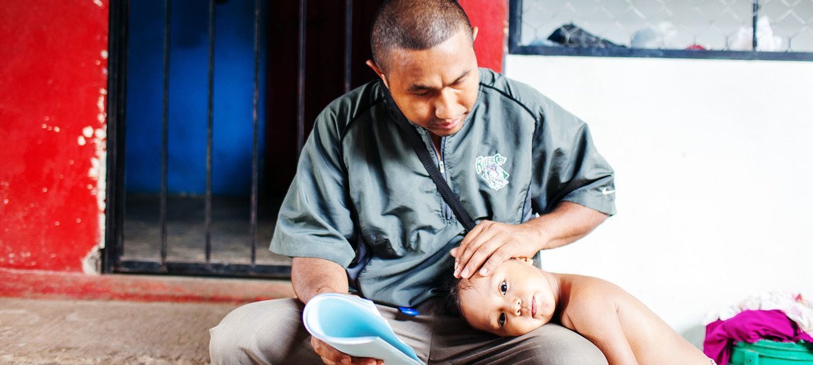 Eduardo, 31, with his daughter Sara at his house in Chiapas, Mexico. Eduardo together with his wife and four daughters, escaped increasing gang violence from El Salvador and have been recognized as refugees in Mexico.